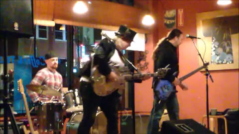Bex Marshall Band live at Dedham Square Coffee House, Massachusetts. L–R: Nigel Ball (bass), Bex Marshall (guitar/vocals), Alexei Gittens (drums).