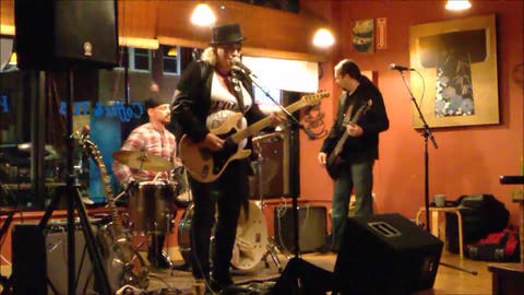 Bex Marshall Band live at Dedham Square Coffee House, Massachusetts. L–R: Nigel Ball (bass), Bex Marshall (vocals/guitar), Alexei Gittens (drums).