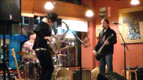 Bex Marshall Band live at Dedham Square Coffee House, Massachusetts. L–R: Nigel Ball (bass), Bex Marshall (guitar), Alexei Gittens (drums).