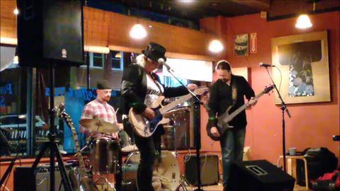Bex Marshall Band live at Dedham Square Coffee House, Massachusetts. L–R: Nigel Ball (bass), Bex Marshall (vocals/guitar), Alexei Gittens (drums).