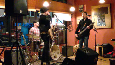 Bex Marshall Band live at Dedham Square Coffee House, Massachusetts. L–R: Nigel Ball (bass), Bex Marshall (vocals/guitar), Alexei Gittens (drums).