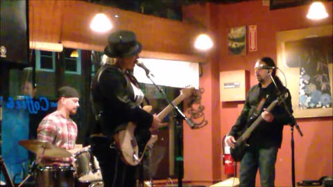 Bex Marshall Band live at Dedham Square Coffee House, Massachusetts. L–R: Nigel Ball (bass), Bex Marshall (guitar/vocals), Alexei Gittens (drums).