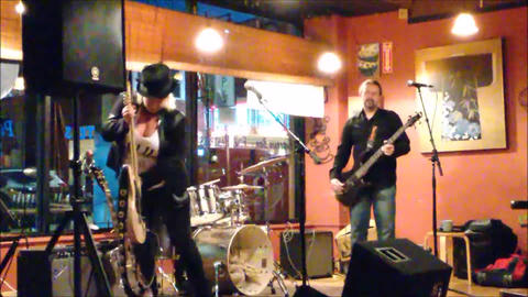 Bex Marshall Band live at Dedham Square Coffee House, Massachusetts. L–R: Nigel Ball (bass), Bex Marshall (vocals/guitar), Alexei Gittens (drums).